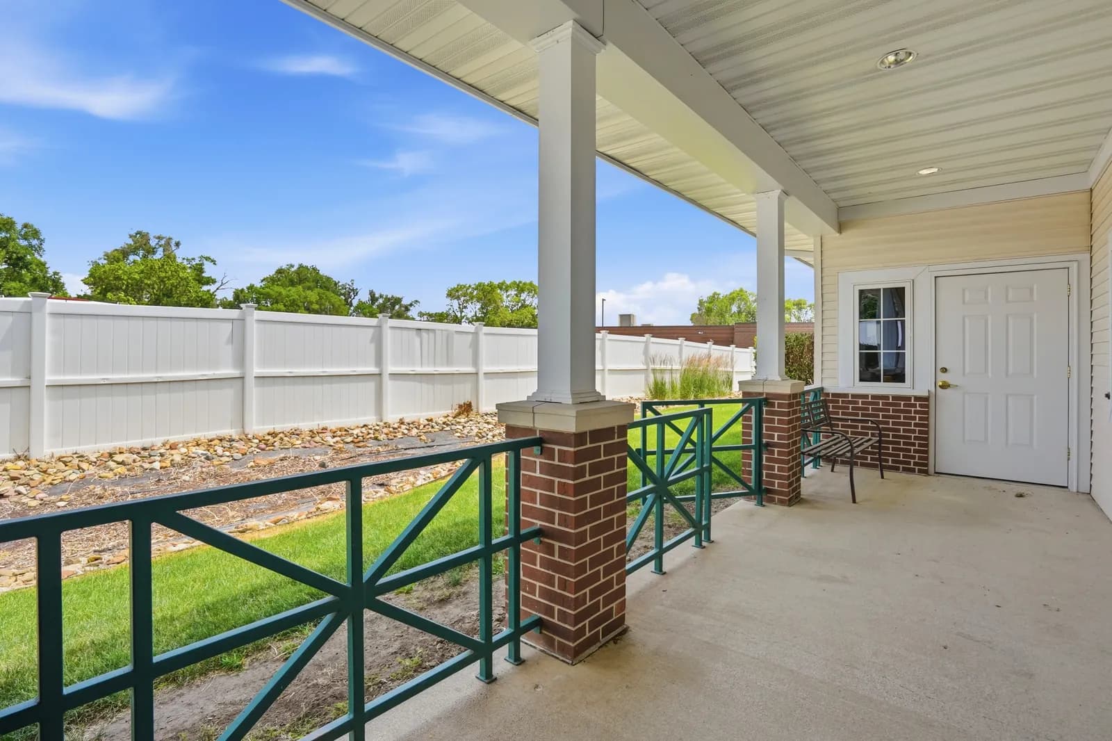 Covered outdoor patio with a private, fenced lawn