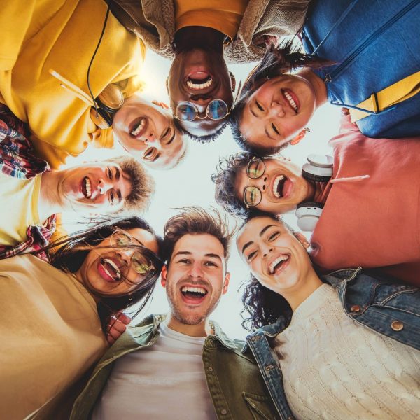 A diverse group of individuals in recovery smiling and supporting one another at Des Moines Wellness Center, representing successful addiction rehab outcomes in Des Moines, Iowa.